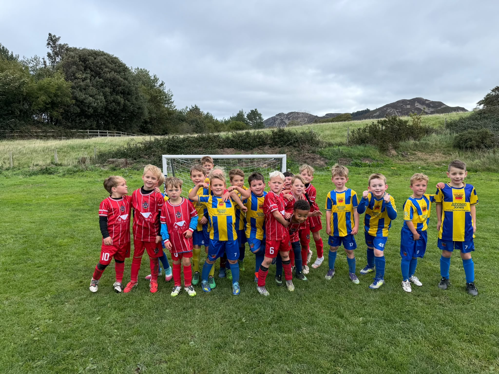 Phoenix U7 boys and their opponents posing together after a game